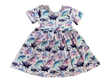 Годишният Бутик за продажба на едро, скъпа детски дрехи за момичета, светло розова рокля до коляното с шарките на малкия динозавър